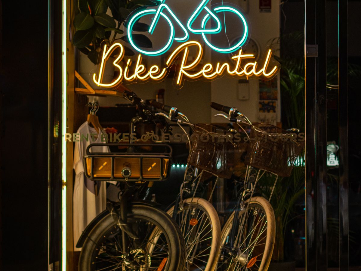 Uthyrningscyklar i en butik med neonskylt Bike Rental